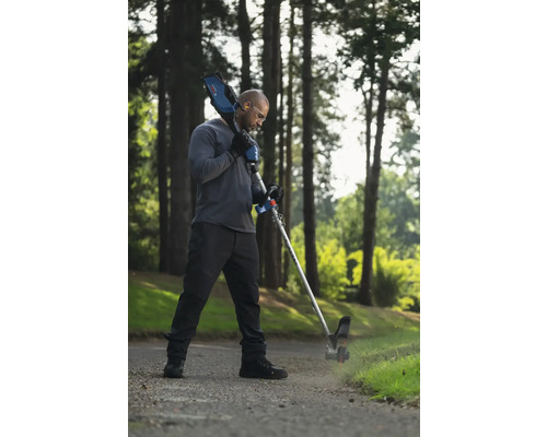 Mann benutzt einen Akku-Kantenschneider für die Gartenarbeit