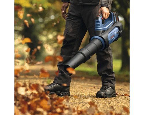 Person benutzt einen Akku-Laubbläser von Bosch im Garten.