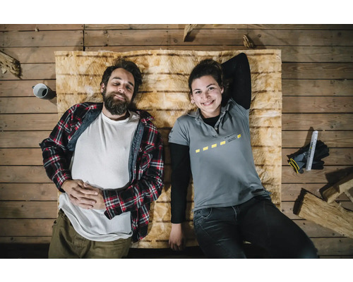 Deux personnes sont allongées sur un matelas isolant sur un plancher en bois.