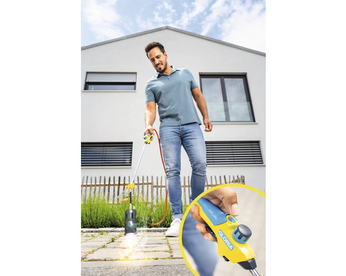 Ein Mann verwendet einen Gasbrenner zur Unkrautbekämpfung im Garten.