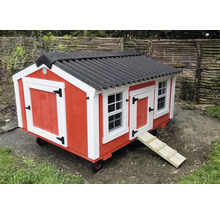 Mobiles rotes Hühnerhaus mit schwarzem Dach, weißen Akzenten, Fenstern und einer Rampe auf Rädern.