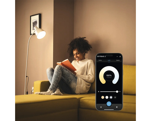 Femme lisant un livre sous un lampadaire contrôlé par une application pour smartphone