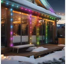 Hausfassade mit mehrfarbiger Lichterkette im Winter