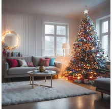 Wohnzimmer mit Sofa, Couchtisch und geschmücktem Weihnachtsbaum
