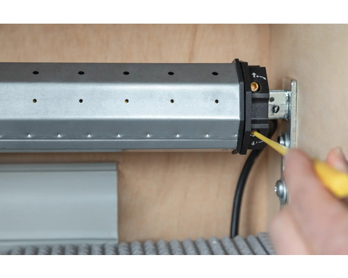 Detailansicht eines Rollladenkastens bei der Installation mit einem Schraubendreher.