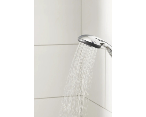 Douchette à main avec eau courante devant des carreaux blancs