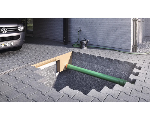 Scène avec caniveau de drainage, tuyau, pavés et voiture