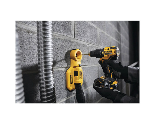 Akkubohrmaschine bohrt mit Staubabsaugung in eine Wand