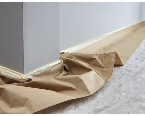 Wand und Boden mit Malerkrepp und Papier abgedeckt.