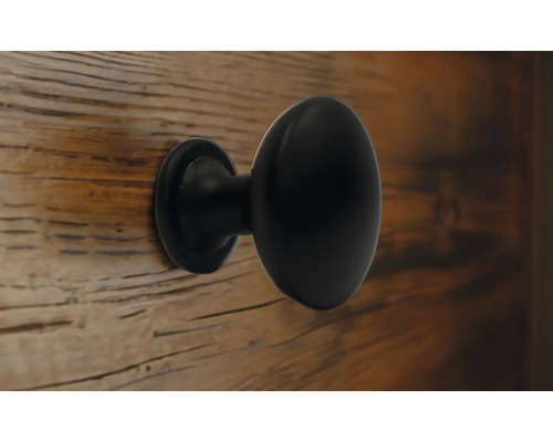 Bouton de meuble noir sur une porte en bois