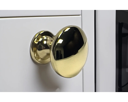 Goldener Möbelknopf an weißer Oberfläche