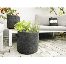 Scène avec deux pots de fleurs gris en feutre avec des herbes et des légumes sur une terrasse
