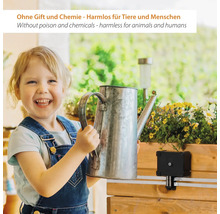 Ein lächelndes Kind hält eine Zinkgießkanne neben einem Blumenkasten mit Bewässerungssystem