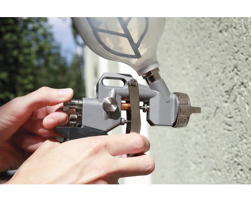 Farbspritzpistole mit Farbbehälter in der Hand