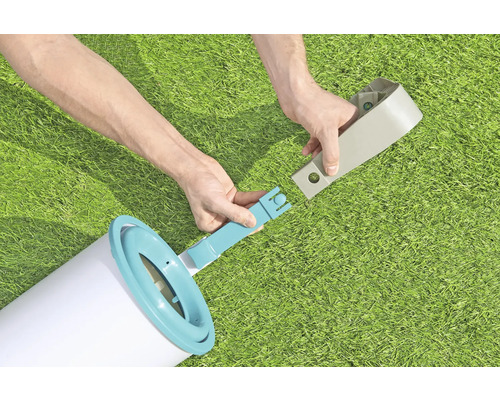 Person montiert eine Poolleiter auf einer Wiese.