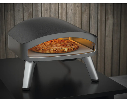 Four à pizza avec pizza à l''intérieur sur une table