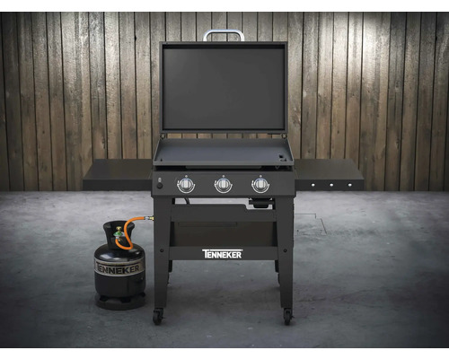 Chariot de barbecue à gaz Tenneker avec bouteille de gaz devant un mur en bois