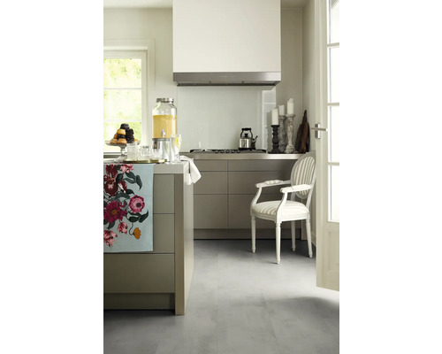 Helle Küche mit Kücheninsel, Dunstabzugshaube, Herd, Armlehnstuhl und Dekorationen.