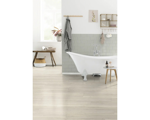 Salle de bains avec baignoire îlot, plancher en bois et carrelage clair