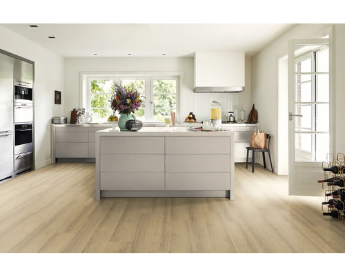 Cuisine claire et spacieuse avec îlot de cuisine, armoires de cuisine et plancher en bois.