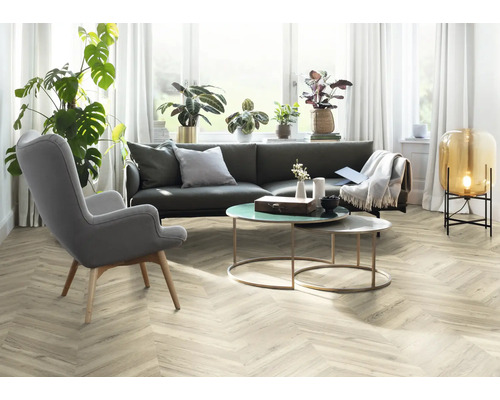 Wohnzimmer mit grauer Couch, Sessel und Dekoartikeln auf dem Tisch