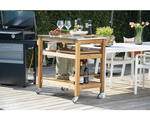 Chariot de grill en bois avec roulettes, surfaces de rangement et plan de travail en acier inoxydable à côté du gril et de la table de jardin