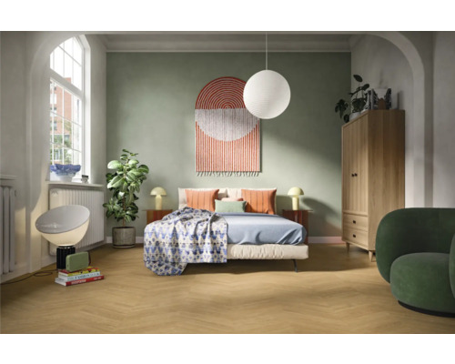 Helles Schlafzimmer mit Bett, Nachttischen, Lampe, Schrank und Sessel