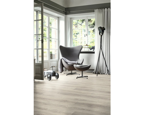 Heller Wohnraum mit Sessel, Stehlampe, Holzfußboden und großem Fenster