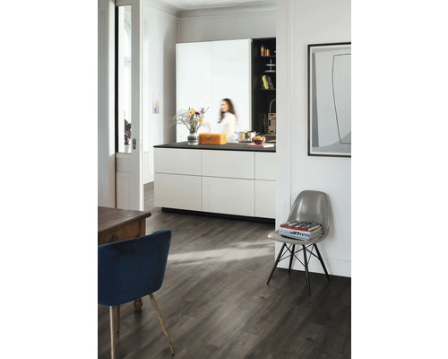 Pièce lumineuse avec cuisine, table à manger et chaise sur parquet foncé.