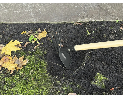 Gartenhacke mit Holzstiel im Beet