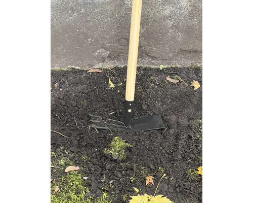 Gartenhacke mit Holzgriff im Erdreich