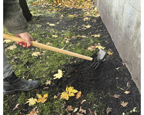 Gartenarbeit mit einer Kombihacke zur Bodenbearbeitung