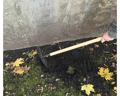 Gartenhacke mit Holzgriff im Einsatz zum Auflockern von Erde