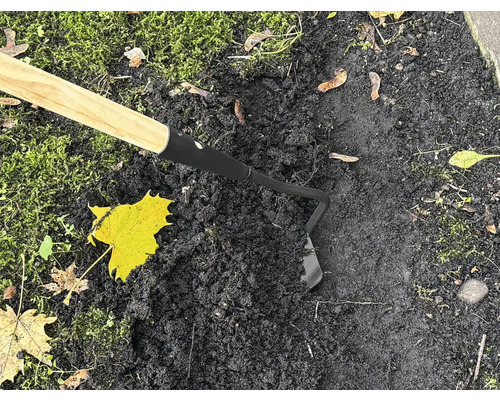 Gartenhacke mit Holzgriff im Einsatz auf dunkler Erde