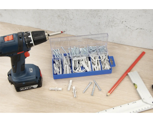 Visseuse sans fil, assortiment de vis et de chevilles sur un plan de travail