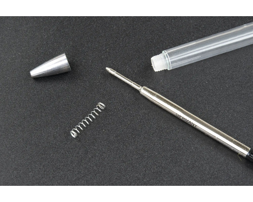 Einzelteile eines Kugelschreibers: Kappe, Gehäuse, Feder und Mine