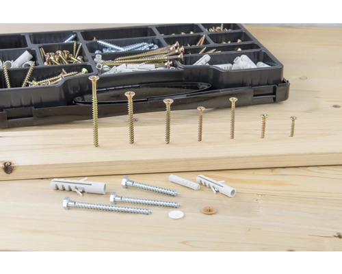 Boîte d''assortiment avec différentes vis et chevilles sur fond en bois