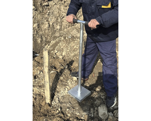 Un homme compacte le sol avec une dame à main