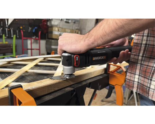 Un homme coupe du bois avec un outil multifonction oscillant de Worx