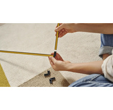 Une personne assemble une moulure décorative de couleur or avec des raccords d''angle.