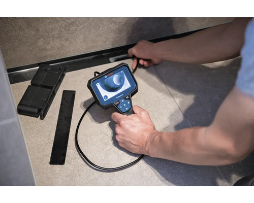 Un artisan utilise une caméra d''inspection pour examiner un tuyau