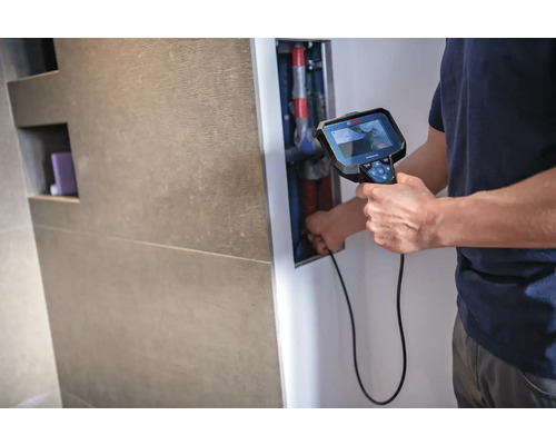 Un homme utilise un outil de caméra d''inspection pour l''inspection des tuyaux dans la salle de bains.