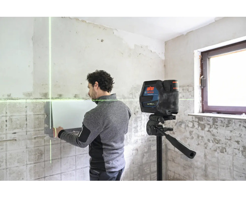 Un homme travaille avec un laser linéaire dans une pièce.