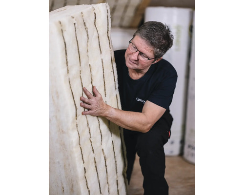 Ein Mann hält eine Platte aus flexibler Holzfaserdämmung.