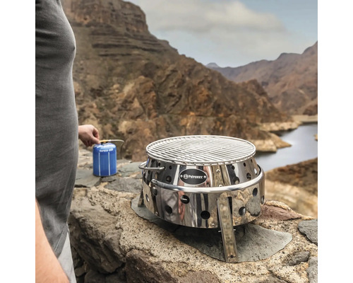 Grill et cuisinière Petromax Atago avec brûleur à cartouche de gaz devant un paysage de montagne