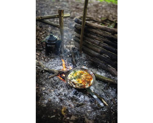 Szene im Freien mit Lagerfeuer, Bratpfanne mit Speise und einer Kanne.