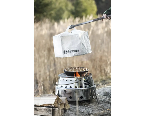 Gril Petromax Atago avec housse de protection, pince et plat préparé en extérieur