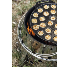 Poffertjespfanne auf einem Holzkohlegrill mit Feuer.