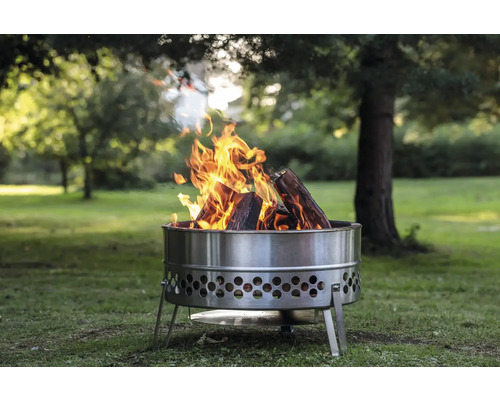 Feuerstelle aus Metall mit brennendem Holz im Garten.