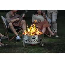 Feuerstelle aus Stahl mit brennendem Holz und Personen im Hintergrund